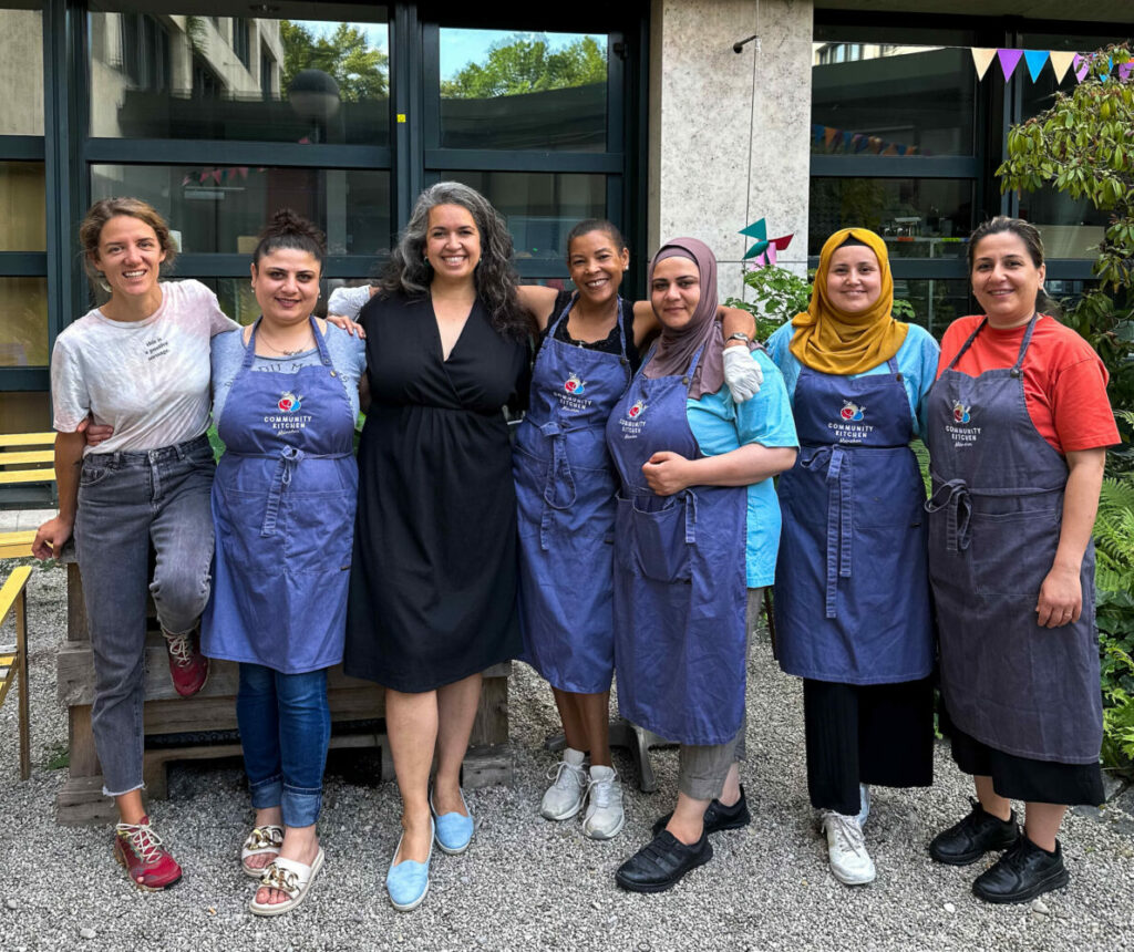 Günes Seyfarth (in black dress, center) and her team at Community Kitchen München, a food-waste restaurant in Munich, Germany. Co-founder Judith Stiegelmayr is on the far left. (Credit: Hannah Hall)
