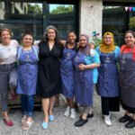 Günes Seyfarth (in black dress, center) and her team at Community Kitchen München, a food-waste restaurant in Munich, Germany. Co-founder Judith Stiegelmayr is on the far left. (Credit: Hannah Hall)